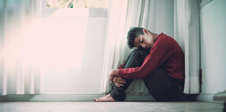 man curled up on floor