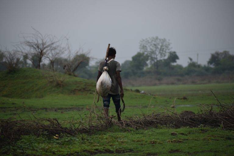 man walking across field